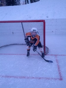 My grandson playing hockey on a cold day. Note the snow bank behind him.