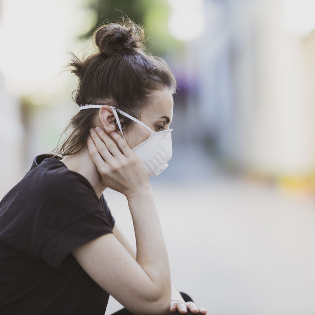 stressed teenage girl wearing a pandemic mask